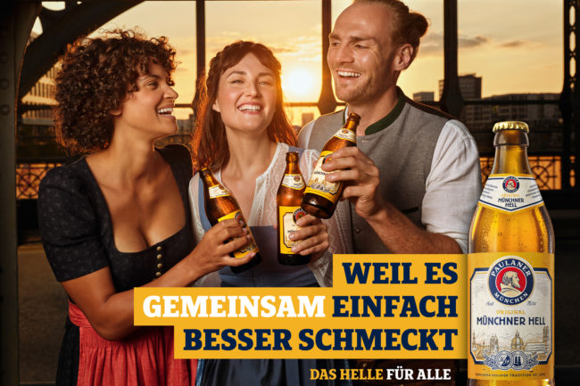 Paulaner Hell beer featured at Hackerbrücke bridge on the way to Oktoberfest, with models in traditional Bavarian clothing